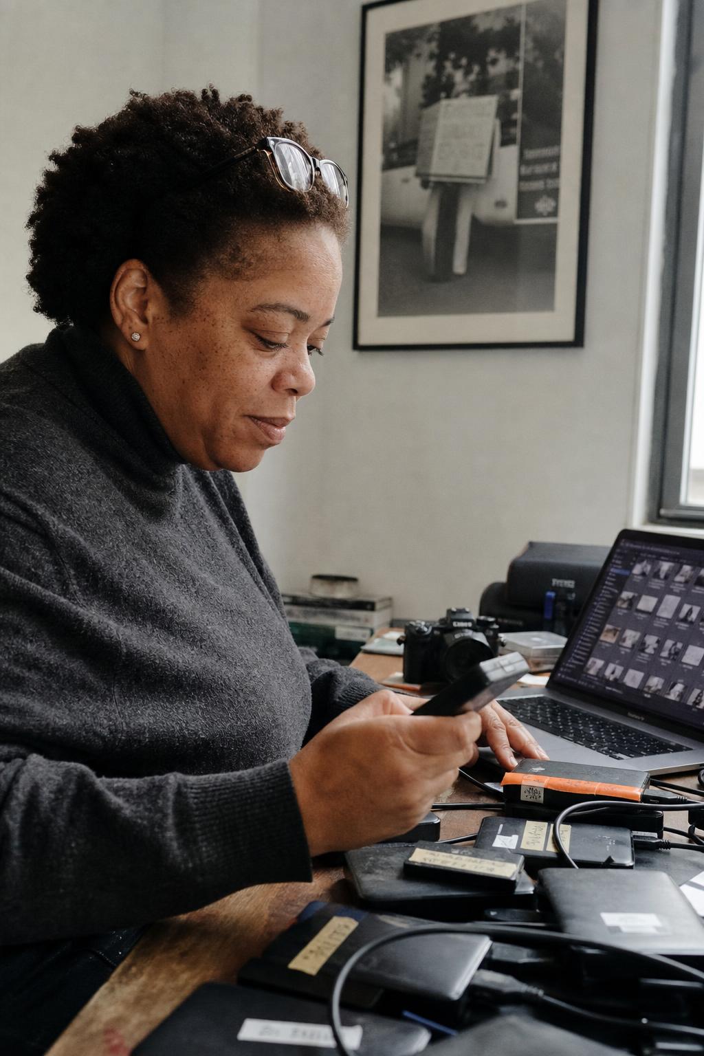 An archivist arranges a row of labeled external hard drives on a walnut shelf — Whimsy cataloguing every disk into one searchable index